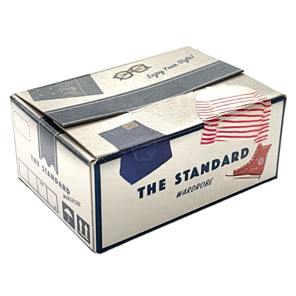A rectangular box called "Japanese Mini Sticker Box The Standard" by Blue Dog Posters, featuring postal graphics, a red-and-white stripe, and an illustration of a shirt with hanger.
