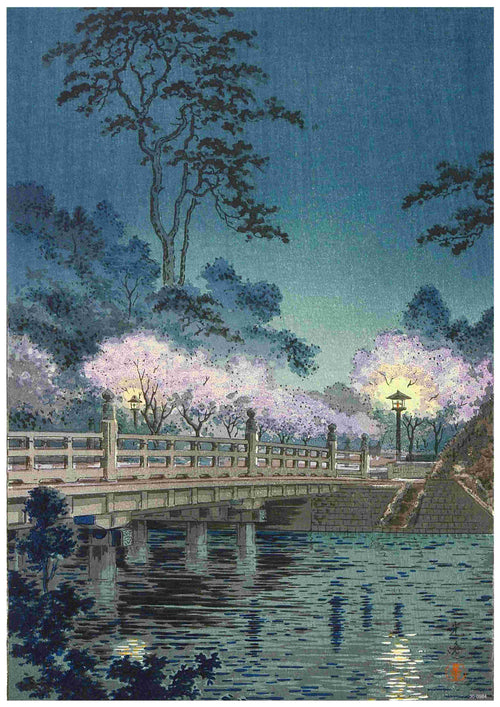 A3's Tsuchiya Koitsu - Beneki Bridge is an artwork depicting a serene night scene with a wooden bridge over calm water, printed on 250gsm Satin Paper. The bridge is lit by lanterns and surrounded by blooming cherry blossom trees, reminiscent of a Japanese Art Poster. Tall trees stretch into the night sky in the background.