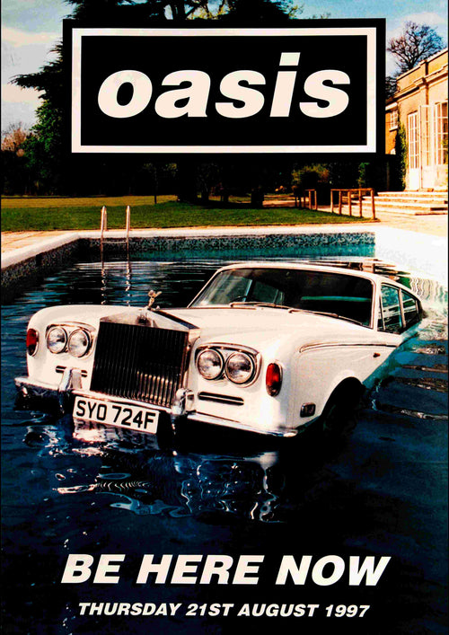 A classic white Rolls-Royce submerged in a pool beside a mansion with trees in the background, featuring the band name "Oasis" and the text "Be Here Now, Thursday 21st August 1997", is captured on Blue Dog Posters' product "Oasis - Be Here Now".