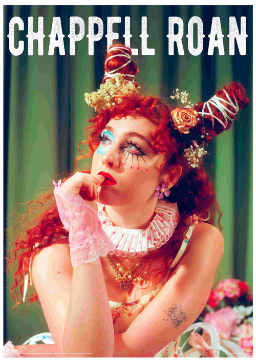 A person with red curly hair in two buns adorned with flowers sits thoughtfully, wearing dramatic makeup, a ruffled collar, and lacy gloves. Ideal for music fans, this A3 satin Chappell Roan poster by Blue Dog Posters features "CHAPPELL ROAN" text above.