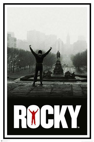 A monochrome image shows a person standing with arms raised triumphantly at the top of a long staircase, with a cityscape in the background. The word "ROCKY" is at the bottom in large white letters, with a small red silhouette of a person raising their arms within the 'O'. Perfect for any Rocky Classic MTV 240 collection.