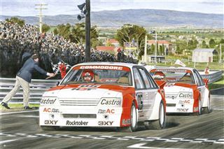 A painting titled "Mike Harbar - Holden Bathurst 1-2 1984" from the CAR 002 brand features two white and red race cars labeled "Commodore" speeding on a racetrack towards the finish line. A crowd in the stands watches as a person waves the checkered flag, with a rural landscape of mountains and trees in the background. This piece is part of our exclusive Motor Sport Poster collection.