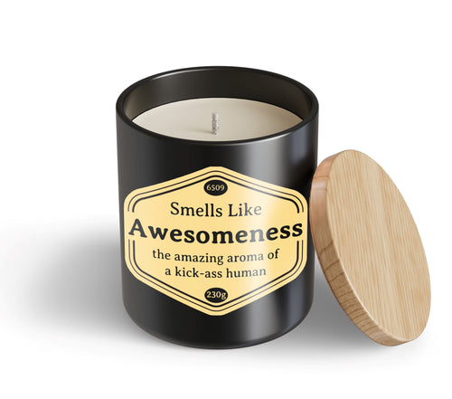 The unused Awesomeness Candle Hustle & Co by Blue Dog Posters is a black jar with a wooden lid and single wick. Its label says, "Smells Like Awesomeness—the amazing aroma of a kick-ass human.
