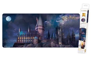 Introducing the Harry Potter - Castle - XXL Gaming Mat from Blue Dog Posters. This premium gaming mat boasts a stunning illuminated Hogwarts Castle at night, with a full moon in the background. The non-slip base ensures stability while providing smooth mouse control, making it an ideal addition to any gaming setup. Displayed both laid out flat and partially rolled up in its packaging, this gaming mat is perfect for any Harry Potter enthusiast.