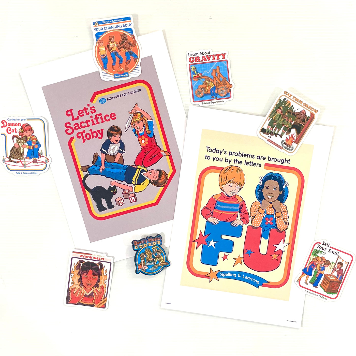 The Mystery Goodie Bag by Steven Rhodes from Blue Dog Posters features parody vintage-style stickers and posters with children and absurd, funny phrases like "Let's Sacrifice Toby" and "Today's problems are brought to you by the letters F U.