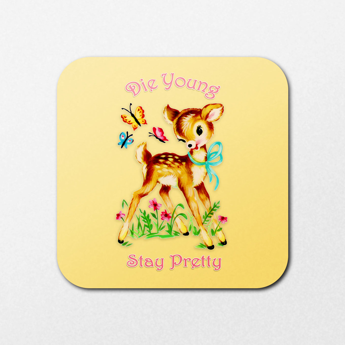 The "Die Young Coaster" by Blue Dog Posters features a vintage-style fawn with a blue ribbon surrounded by butterflies and flowers on a yellow background, along with the text "Die Young Stay Pretty" in pink.