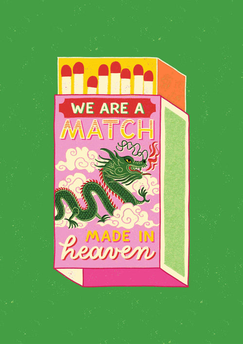 Illustration of a "Match Made in Heaven by Miriam Giudici" matchbox from Blue Dog Posters against a green background. The matchbox is pink and decorated with a green dragon and white clouds, with text reading, "We are a match made in heaven." The top of the box reveals red-tipped matches.