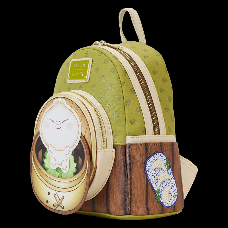 The Bao Bamboo Steamer Mini Backpack by Blue Dog Posters is a small green and brown Vegan Leather Backpack that features a dumpling character in a bamboo steamer design on the front pocket, complete with light beige straps and zippers. Additionally, it includes a blue and white floral-patterned sticker on the lower right side.