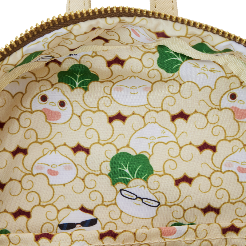 A close-up view of the Bao Bamboo Steamer Mini Backpack's interior lining, featuring a playful pattern of dumplings and leafy greens. Some dumplings have expressive faces and accessorize with glasses and sunglasses. The fabric background is light yellow with tan outlines, brought to you by Blue Dog Posters.