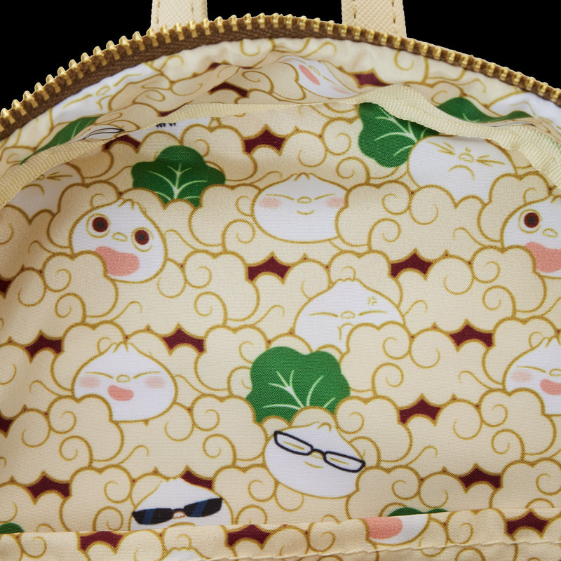 A close-up view of the Bao Bamboo Steamer Mini Backpack's interior lining, featuring a playful pattern of dumplings and leafy greens. Some dumplings have expressive faces and accessorize with glasses and sunglasses. The fabric background is light yellow with tan outlines, brought to you by Blue Dog Posters.
