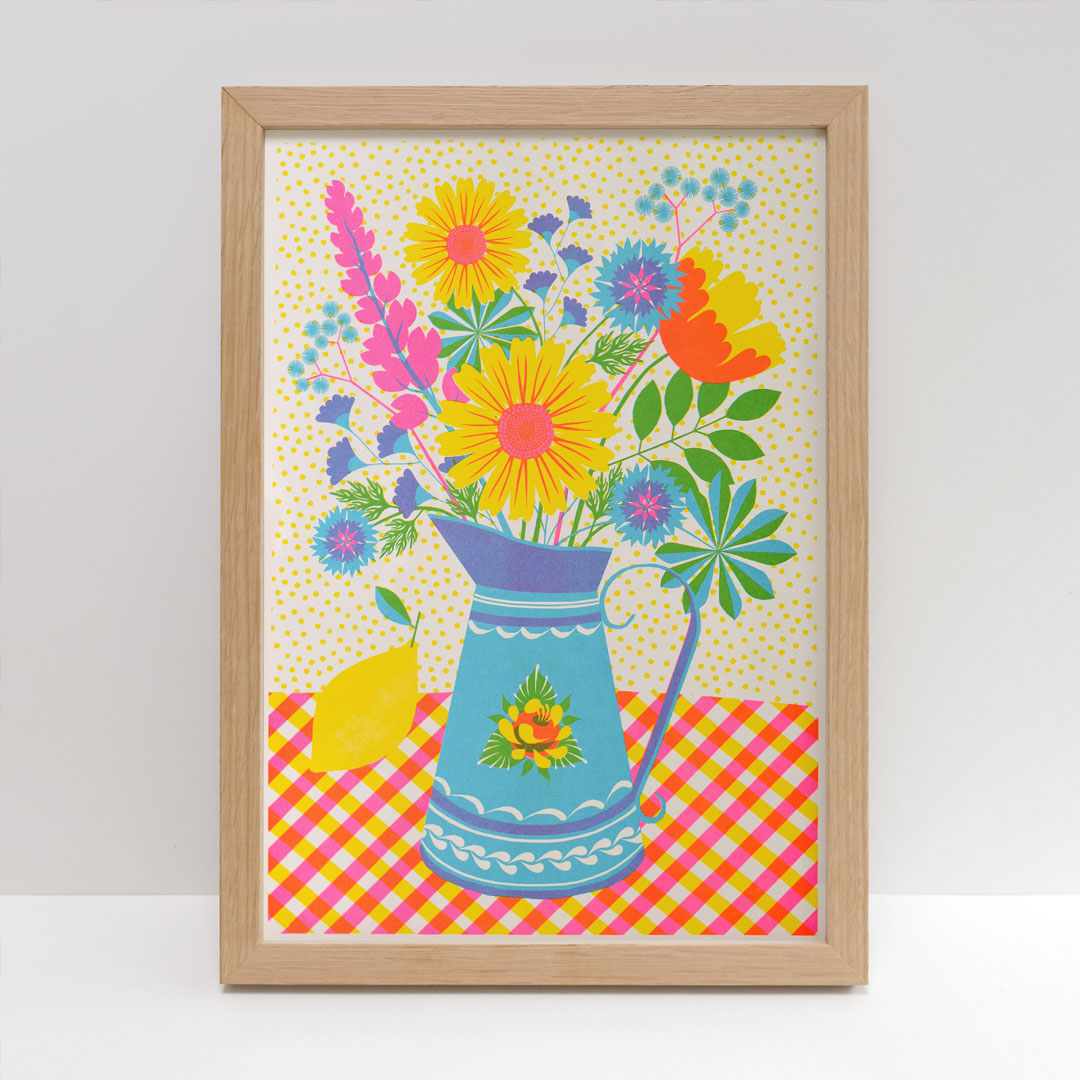 Blue Dog Posters presents 'Summer Bloom Riso' by Printer Johnson—this framed artwork highlights a lively bouquet of flowers in a blue jug set against a yellow polka dot backdrop. The vivid blooms, elegantly displayed on a red and yellow checkered tablecloth, are printed on FSC certified paper using eco-friendly soy-based inks.