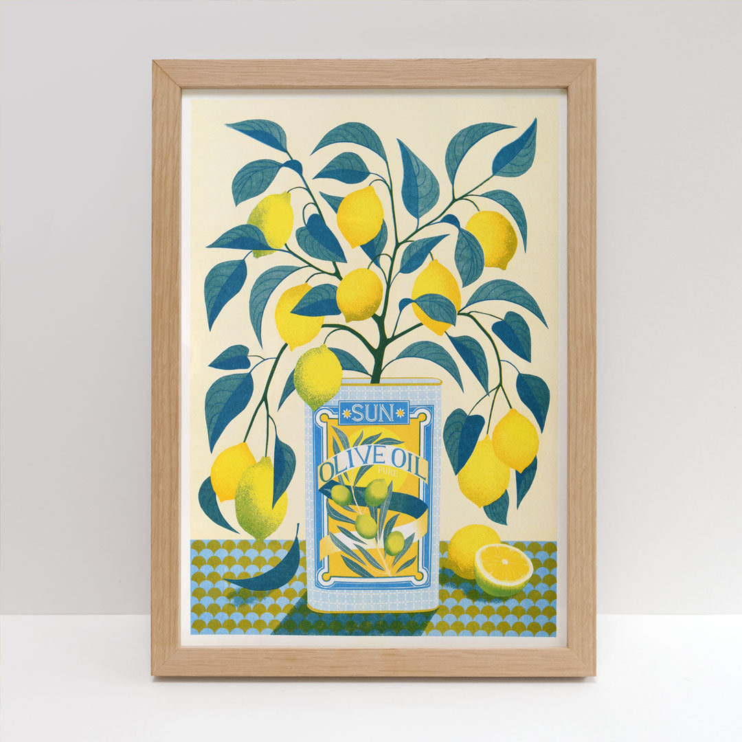 The Lemon Tree Riso Print by Printer Johnson, available from Blue Dog Posters, features a framed illustration of a can labeled "Sun Olive Oil." It depicts a lemon tree with vibrant green leaves and yellow lemons set against a geometric patterned background. Below the scene, a sliced lemon is artfully placed. This Risograph print is crafted using eco-friendly soy-based inks for an environmentally sustainable touch.