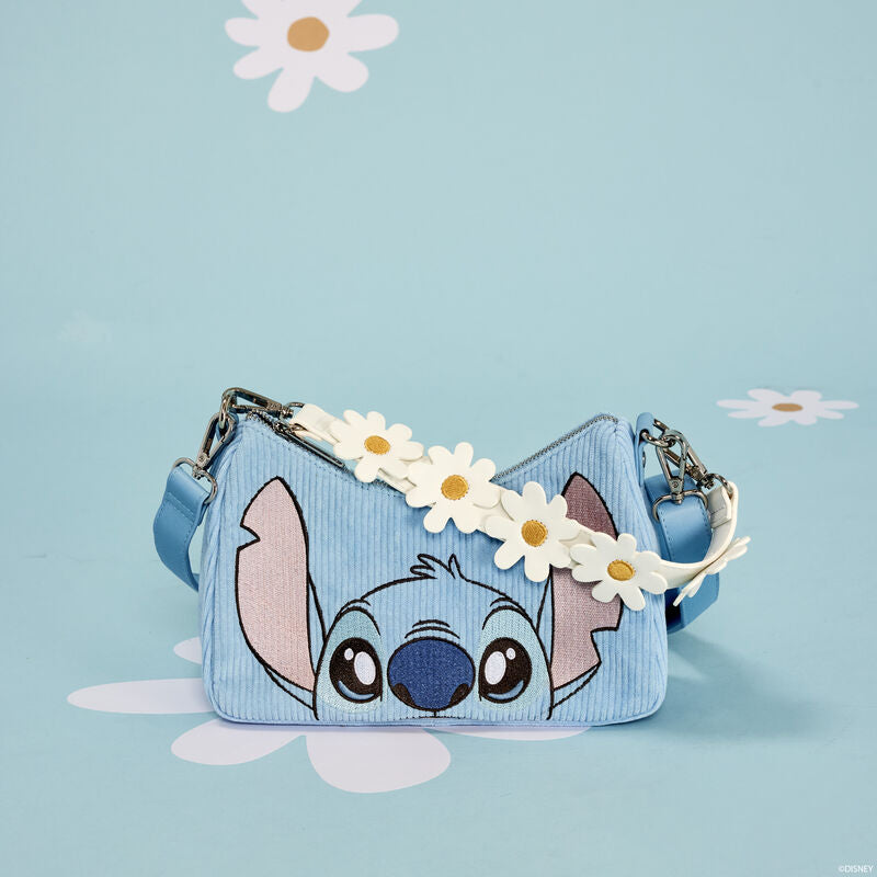 The Lilo & Stitch Springtime Daisy Crossbody by Blue Dog Posters, made from vegan leather, features a light blue handbag with an illustration of Stitch peeking over the top. The strap is adorned with white and yellow daisy flowers, set against a soft blue background scattered with white daisy flowers.
