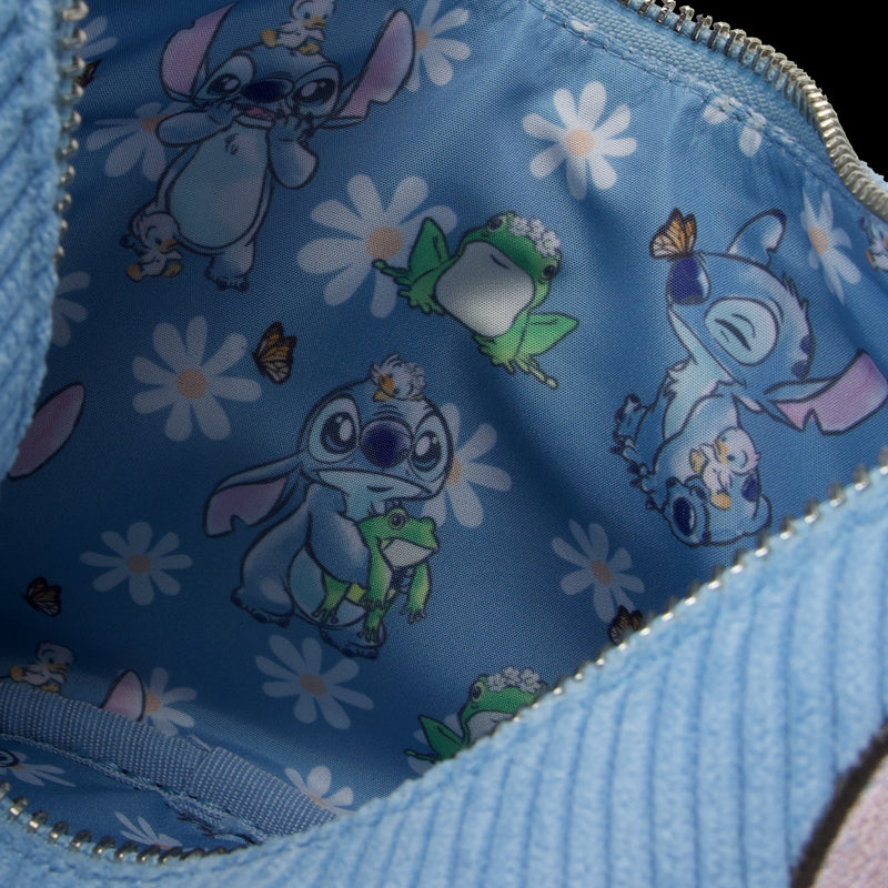 The interior of the Lilo & Stitch Springtime Daisy Crossbody from Blue Dog Posters features a whimsical pattern with images of the animated character in different poses. Stitch interacts with a frog, butterflies, and small creatures against a backdrop of white flowers on blue vegan leather—truly a delightful Disney product.