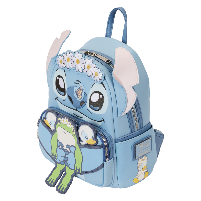 The Lilo & Stitch Springtime Mini Backpack from Blue Dog Posters, inspired by Disney's "Lilo & Stitch," is adorned with a daisy headband to resemble Stitch. The front pocket showcases frog and duckling characters also wearing daisy headbands. This cosplay backpack features blue straps and a zippered front pocket.