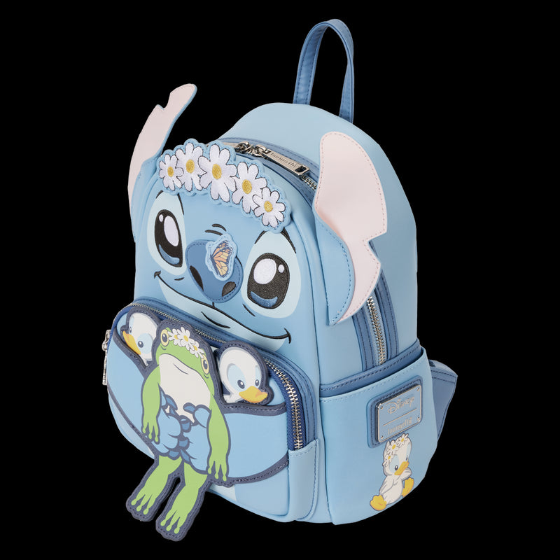 The Lilo & Stitch Springtime Mini Backpack from Blue Dog Posters, inspired by Disney's "Lilo & Stitch," is adorned with a daisy headband to resemble Stitch. The front pocket showcases frog and duckling characters also wearing daisy headbands. This cosplay backpack features blue straps and a zippered front pocket.