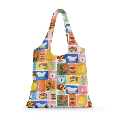 The Blue Dog Posters Aussie Icons Reusable Shopping Bag features vibrant koalas, lemons, bread, tea, and more on a patchwork background. With wide handles and a flat bottom, it's a sustainable and stylish choice for everyday use.