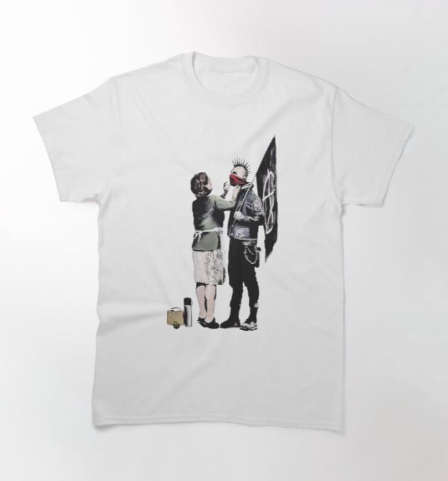 This super cool Banksy Mum & Punk T-shirt White MED from Blue Dog Posters features artwork depicting a woman in a dress, apron, and headscarf standing face-to-face with a person dressed in punk attire with a spiked mohawk and holding a flag. The woman is pinning a flower onto the punk's jacket. Available in multiple sizes, it's perfect for artist support enthusiasts.