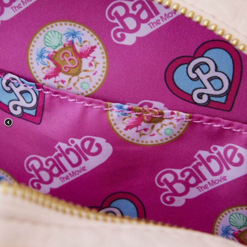 Close-up photo of the interior lining of a Barbie the Movie Logo Crossbody Bag by Blue Dog Posters. The pink lining features various prints, including hearts, flamingos, seashells, and the words "Barbie The Movie" in different patterns and arrangements. The zipper and stitching are visible.