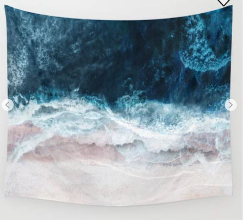 An aerial view of ocean waves crashing onto a sandy beach is beautifully captured in the vibrant design of the Blue Sea II by Nadja Art Textile Lge from Blue Dog Posters. The deep blue water transitions into foamy white waves as they meet the shoreline, creating a dynamic and textured pattern against the pale sand—ideal inspiration for these lightweight wall tapestries.