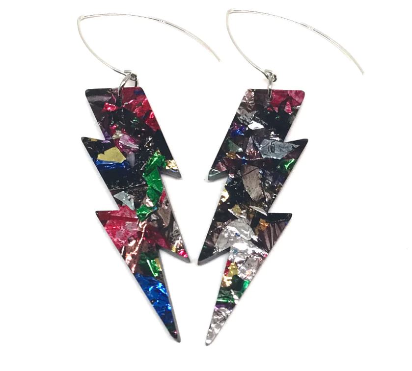 Two stunning Lightning Bolt Crinkle Glitter Earrings featuring a colorful, fragmented pattern crafted by Blue Dog Posters. With hues of red, green, blue, gold, and silver, these handmade jewelry pieces create a bold and vibrant look. They elegantly hang on silver hooks.