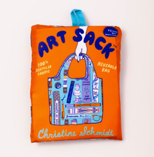 The "Bookbag Art Sack" by Blue Dog Posters is a folded, orange reusable bag made from 100% recycled rPet fabric. It features a design with various art supplies and tools and is adorned with the name "Christine Schmidt" at the bottom. Additionally, it includes a blue fabric loop for easy carrying, making it both stylish and eco-friendly.