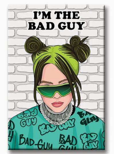 An illustration features a person with green hair styled in two buns, donning oversized green sunglasses and a "BAD GUY" patterned shirt. They pose against a white brick wall decorated with bold magnet letters from the Billie Eilish Bad Guy Magnet by Blue Dog Posters, displaying the phrase "I'M THE BAD GUY" at the top.