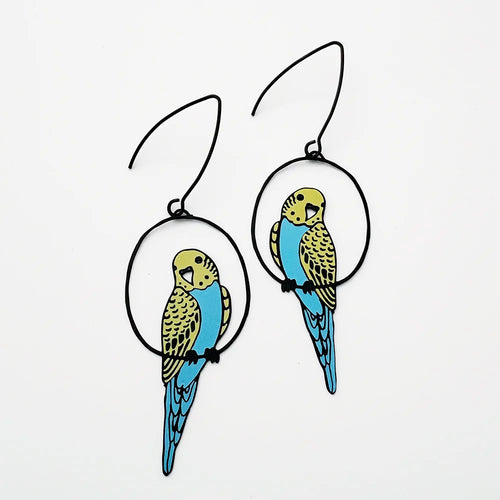 Blue Dog Posters’ Budgie Black Blue Yellow Denz Earrings feature vibrant parakeet designs in yellow, blue, and black, each perched inside a black circular frame.
