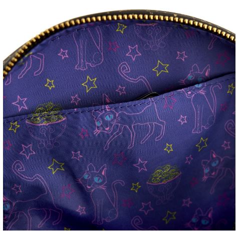 An open Blue Dog Posters Coraline - Moon Crossbody reveals a purple interior decorated with whimsical designs of large-eyed cats, stars, and UFOs in neon pink, yellow, and green. Made from vegan leather, this glow-in-the-dark accessory offers a playful yet ethical touch.