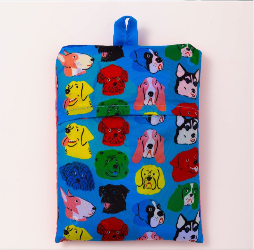 The Dogs Art Sack, designed by Blue Dog Posters and created by Kristina Micotti, is a blue foldable bag adorned with colorful cartoon dog faces of various breeds and colors. This Eco-friendly sack is made from 100% recycled rPet and includes a small blue loop at the top for convenient hanging or carrying.