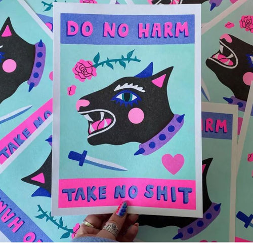 A hand holding the "Do No Harm A4 Risograph by Amy Hastings" from Blue Dog Posters, featuring a stylized black cat adorned with pink spots and a blue spiked collar. Above the cat are the words "DO NO HARM," and below it, "TAKE NO SHIT," along with illustrations of a heart, dagger, and rose. The background showcases repeating patterns of this unique Risograph print on recycled coffee cup paper.