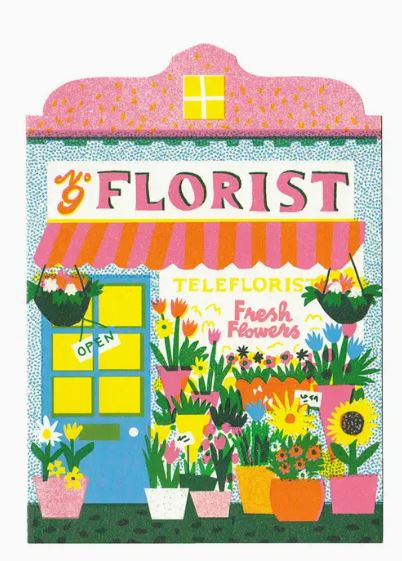 Illustration of a charming florist shop with a blue door, hanging flower baskets, and a variety of colorful potted plants outside. The shop, known for its Mother's Day specials, has a pink and white striped awning. Shop-themed cards are displayed in biodegradable cello bags near the sign that reads "Florist" with "Fresh Flowers" below; these feature the Florist Studio Die Cut Riso Card by Blue Dog Posters.