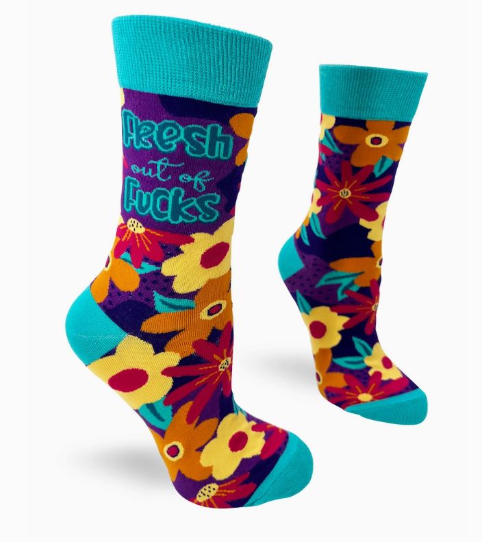 The Fresh Out of Fucks Socks Ladies by Blue Dog Posters are a pair of colorful socks featuring a vibrant floral pattern with yellow, orange, red, and purple flowers accompanied by green leaves. The turquoise accents include the text "Fresh out of Fucks" written on the sides.