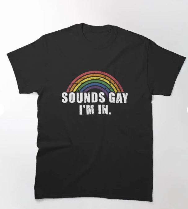 Blue Dog Posters' Sounds Gay T-shirt in size small features a black color scheme adorned with bold white lettering that reads "SOUNDS GAY I'M IN." Positioned above the text is a stylized rainbow in red, orange, yellow, green, blue, and purple hues. The design includes a slightly distressed effect for an artistic touch.