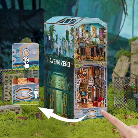 A hand points to the vibrant "Haven Zero Large Book Nook Tonecheer" by Blue Dog Posters, displayed in a lush post-apocalyptic diorama. Illustrated icons highlight interactive touch and sound features for this unique DIY book nook.