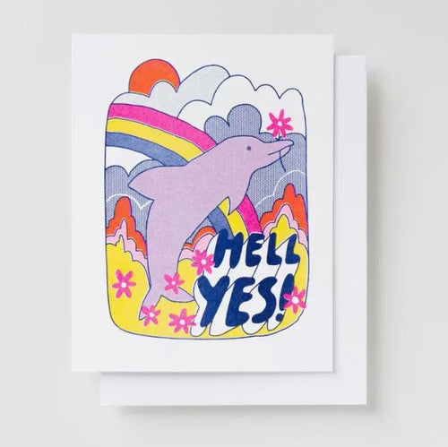 Introducing the Hell Yes Dolphin Risograph Card by Blue Dog Posters: a greeting card featuring a pastel-colored dolphin leaping against a backdrop of a vibrant rainbow, sun, and clouds. Pink flowers are dotted around the joyful dolphin, with the words "HELL YES!" prominently displayed at the bottom in dark blue. This unique card is printed on recycled paper using eco-friendly veggie-based inks.
