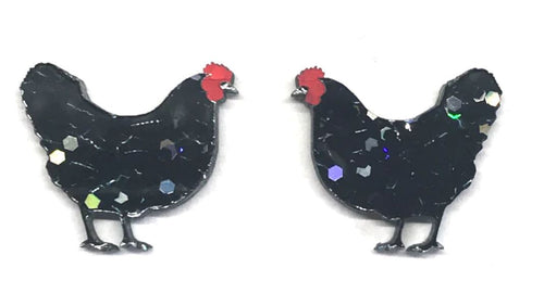 Two Hen Glitter Stud Earrings Black from Blue Dog Posters, designed to resemble black chickens, face each other against a white background. They showcase red combs and glittery black bodies adorned with multicolored reflective elements. Handmade in Melbourne, these earrings add a unique touch to any outfit.