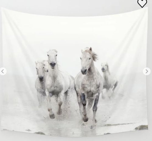 A set of four white horses gallops through shallow water, creating splashes against a misty, white background. This image perfectly encapsulates their motion and energy, with the horses appearing powerful and dynamic—an ideal representation of beauty that can be showcased on the **Camargue White Horses Art Textile Sml** by **Blue Dog Posters**.