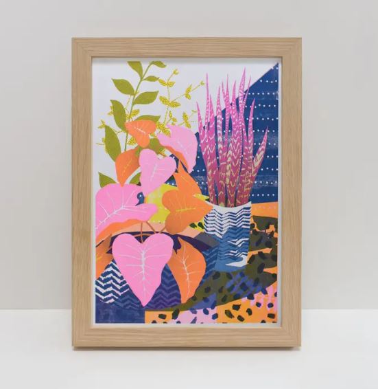 The House Plants A4 Riso Print by Printer Johnson from Blue Dog Posters showcases framed artwork with vibrant abstract plants in pink, orange, and green leaves against tall purple stalks. The background features a mix of blue, orange, and dotted patterns.