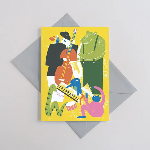 The Jazzy Reptiles Greeting Card by Blue Dog Posters features a vibrant scene of animal friends playing instruments, printed on plastic-free yellow card and comes with a gray envelope.