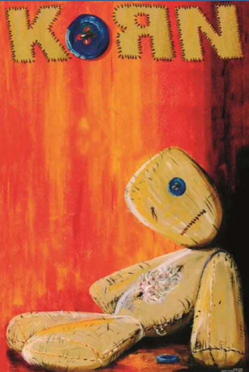The Korn Teddy by MUS 301 features a stitched yellow ragdoll with button eyes against a red-orange background. "KORN" appears in patchwork letters with a blue button "O." This Pop Poster is perfect for any music collection.