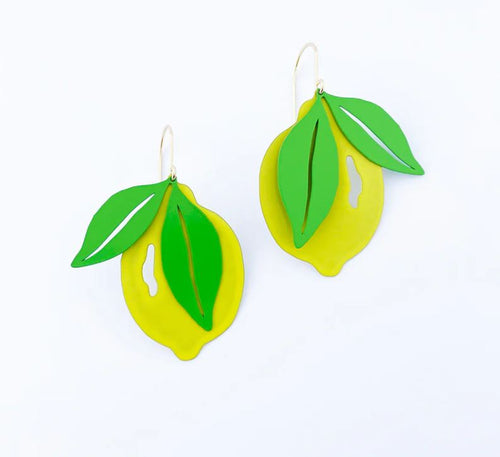 The Lemon Dangle Denz Earrings by Blue Dog Posters are designed to resemble bright yellow lemons with green leaves. Each lemon and its leaves are attached to simple surgical steel hooks, offering both style and durability. The bold and colorful design stands out beautifully against a plain background.
