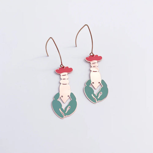 The Lobster in Coral Denz Earrings by Blue Dog Posters are lightweight and stylish, featuring a vibrant midi lobster design in red, pink, and teal. These earrings come with hooks for easy wearing and are elegantly displayed against a plain white background.