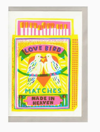 A vibrant illustration adorns the "Love Bird Matches Riso Card" from Blue Dog Posters. Perfect for a Valentine's Day card, it features two white doves facing each other, framed by a heart and stars, with "Made in Heaven" written at the bottom. The colors are bright and include yellow, pink, and lime green.