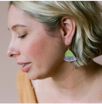 A woman with short blonde hair and closed eyes is shown in profile, wearing Blue Dog Posters' Mini Gum Blossom Pistachio & Lilac Earrings and a tan top against a neutral background.