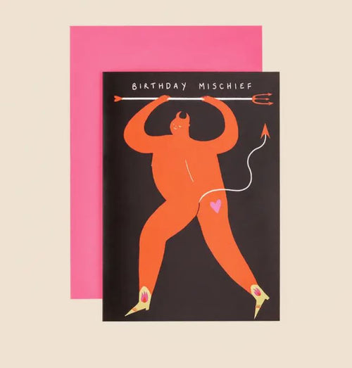 A Mischief Birthday Greeting Card from Blue Dog Posters featuring an orange devil holding a pitchfork with "Birthday Mischief" written above. The devil has a heart on its rear. Behind the card is a bright pink envelope, perfect for sending your birthday wishes from Manchester, UK.