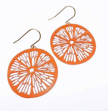 The Denz Citrus Slice Earrings in Orange by Blue Dog Posters show off intricate cut-out designs and are attached to gold hooks, all set against a white background.