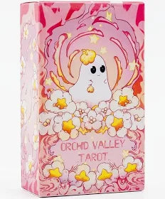The Orchid Valley Tarot Cards by Blue Dog Posters come in a pink and orange box with a cute, ghost-like character surrounded by yellow and white flowers and stars.