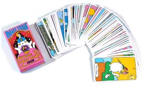 A deck of Cat Paws Tarot Cards with cartoon cat illustrations is fanned out. The box on the left, from Blue Dog Posters, features a cat holding a crystal ball and includes the subtitle "Future in Your Paws.