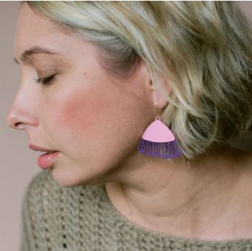 A woman with short blonde hair, in a knitted beige sweater and Blue Dog Posters' Mini Gum Blossom Pink & Eggplant Earrings, is shown in profile with her eyes closed.